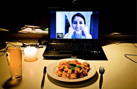Virtual dinner date with meal and candle on video call