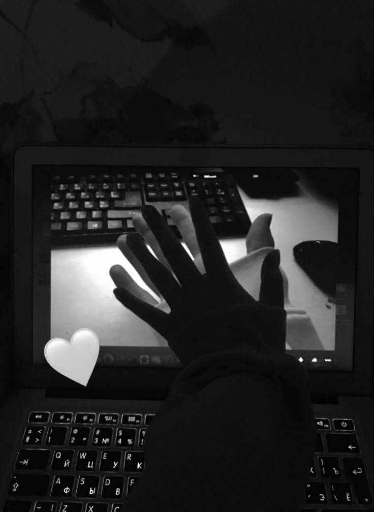 Hand reaching toward a partner on a laptop video call
