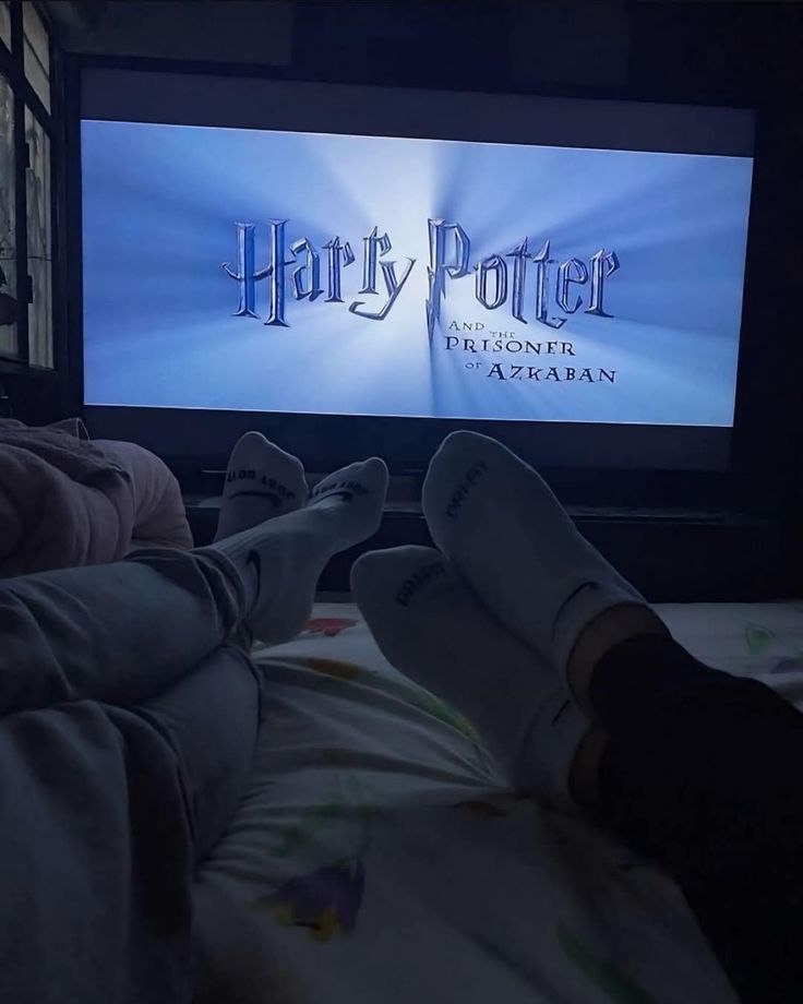Couple watching a movie together in bed on a shared movie night