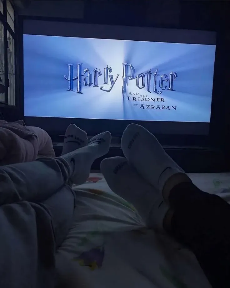 Couple watching a movie together in bed on a shared movie night